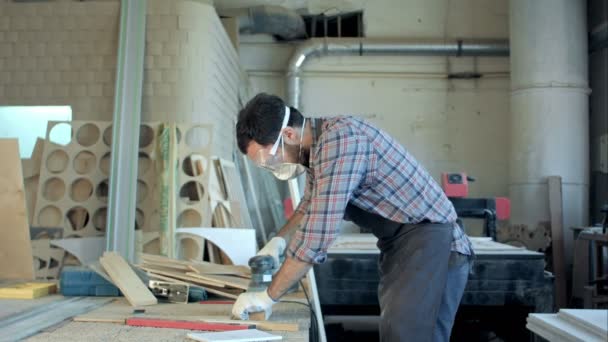 Falegname barbuto che lavora con pialla elettrica su tavola di legno in officina . — Video Stock