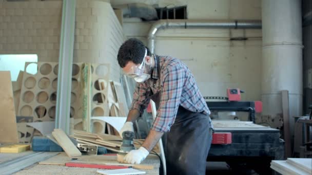 Falegname barbuto in occhiali di sicurezza che lavora con pialla elettrica in officina . — Video Stock