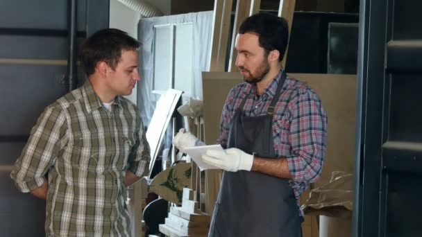 Dos carpinteros discutiendo algo en el taller . — Vídeos de Stock
