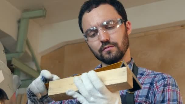 A carpenter works on woodworking with wood plank. — Stock Video