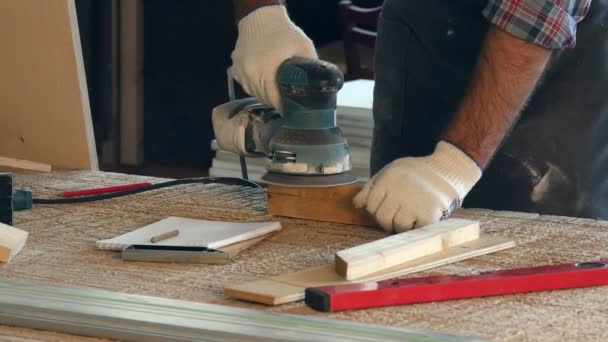 Man working with wooden planck and electric planer write in notebook. — Stock Video