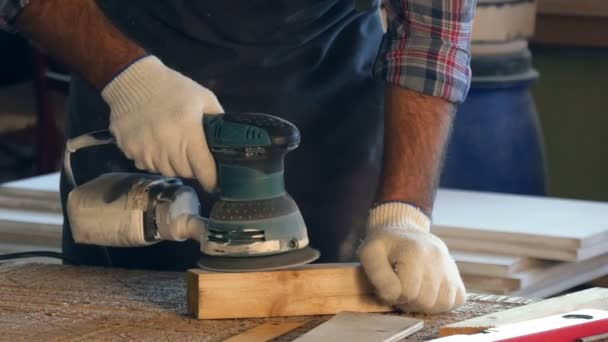 De zarpenter werkt met elektrische Planer op houten plank in workshop. Handen. — Stockvideo