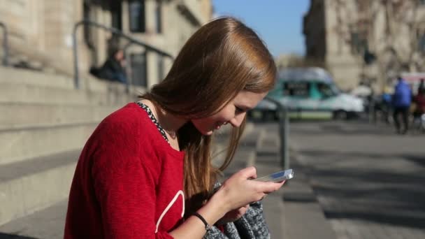 Hezká žena, hledání podle smartphone sedací schody — Stock video