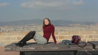Etrafa ve şehrin en üst noktada bir bankta güneşlenme smileing kız
