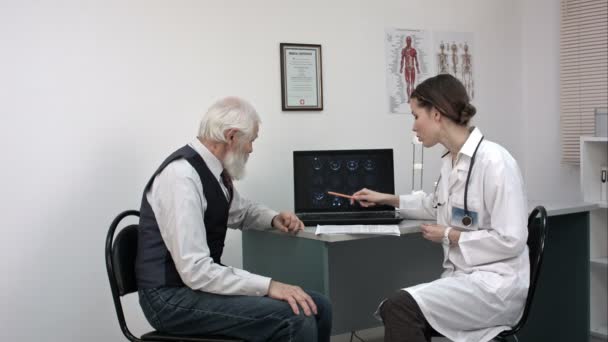 Médico mostrando pacientes ancianos mri resultados en el ordenador portátil . — Vídeos de Stock