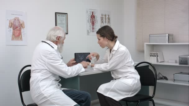 Pasante mostrando al médico la radiografía en la pantalla de la tableta . — Vídeo de stock