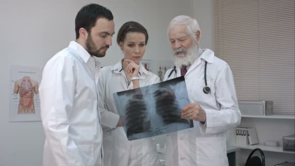 Group of doctors and nurse looking at X-ray. — Stock Video