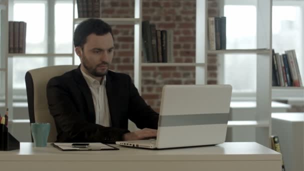 Бизнесмен, работающий за компьютером в офисе во время ввода на клавиатуре — стоковое видео