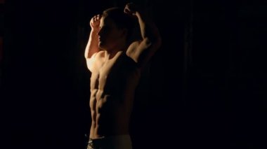 siyah arka plan üzerinde poz kaslı vücut geliştirmeci.