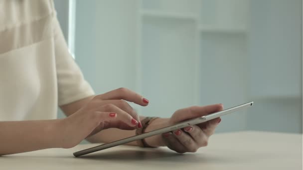 Frau sitzt am Bürotisch und tippt Tablet an — Stockvideo