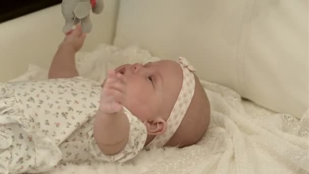 Ευτυχισμένο μωρό που παίζει με κρεβάτι πλευρά παιχνίδι, χαμογελώντας — Αρχείο Βίντεο