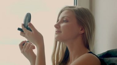 Makyaj kadın. kadın sevimli kozmetik makyaj ürünleri ile eğleniyor.