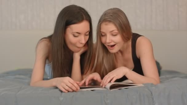 Two Beautiful Women with magazine in the Bedroom — Stock Video