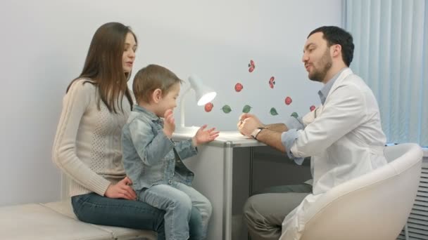 Doctor talking to young child and mother — Stock Video