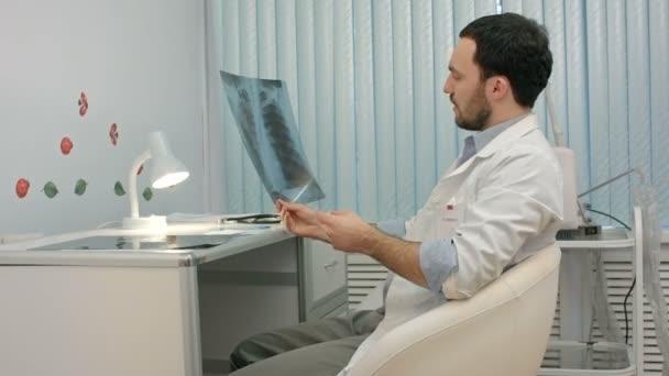 Médico o dentista masculino mirando rayos X — Vídeos de Stock