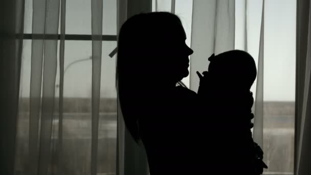 Silhouette of mother throwing baby up — Stock Video