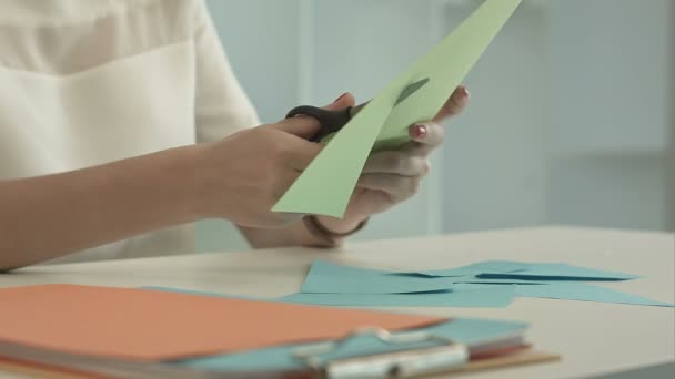 La mujer está cortando papel verde usando tijeras — Vídeo de stock