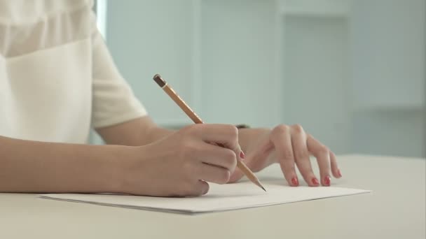 Mujer con lápiz escribiendo sobre papel — Vídeos de Stock