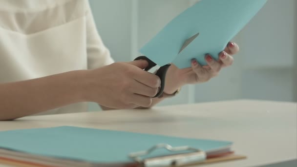 Meisje is snijden kleur blauw papier met een schaar — Stockvideo