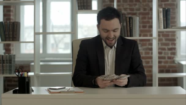 Бізнесмен в офісі насолоджується своїми грошима — стокове відео