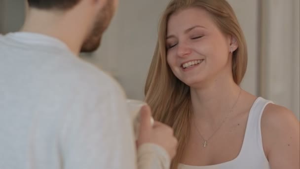 Young man giving a good morning kiss to his wife in the kitchen — Stock Video