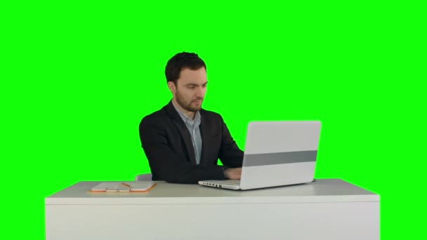 Young businessman concentrating on working with laptop computer on a Green Screen — Stockvideo