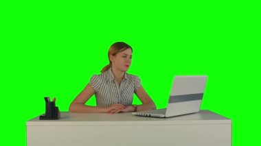 Woman is working on the laptop on a Green Screen