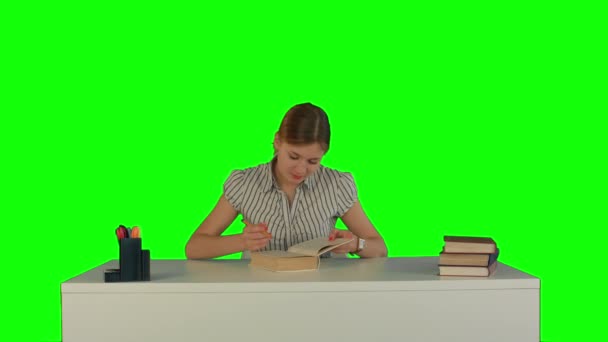 Piękna studentka czytać książkę na zielonym ekranie — Wideo stockowe