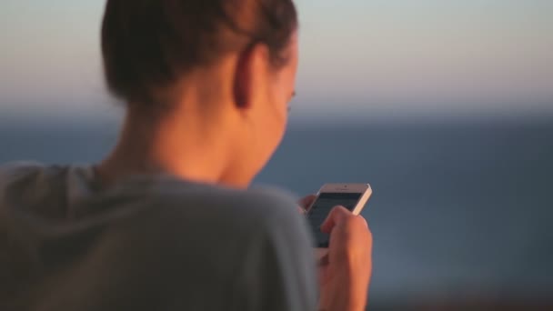 Mujer joven disfrutando con vista al mar uso de teléfono inteligente — Vídeos de Stock