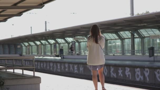 Jeune femme en attente d'un train à quai à la gare portugaise — Video