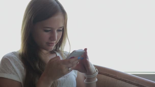 Close up of young beautiful girl sits in a cafe holding smart phone — Stock Video