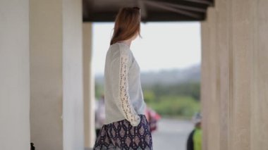 Young pretty girl tourist at the bus stop useing smartphone. Countryside. Europe