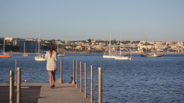 Chica caminando por la noche en el muelle del puerto deportivo, en la costa atlántica del océano en Portugal cascais — Vídeos de Stock