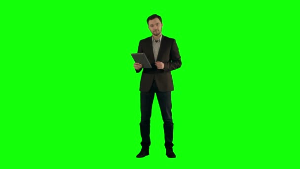Hombre de negocios fresco usando tableta electrónica en una pantalla verde — Vídeos de Stock