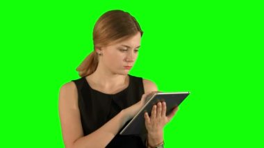 Young woman using a tablet on a Green Screen
