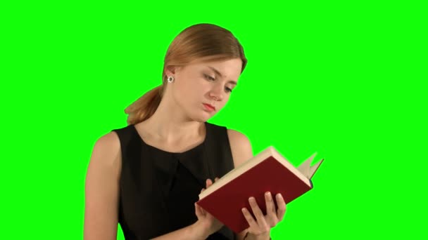 Молодая красивая девушка читает книгу на ноутбуке на зеленом экране, Chroma Key — стоковое видео