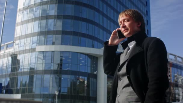 Счастливый бизнесмен, использующий мобильный телефон вне офиса — стоковое видео