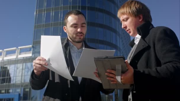 Dos jóvenes empresarios discutiendo el documento — Vídeos de Stock