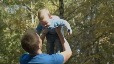 Baba oğul bir sonbahar Park havaya fırlatır. Mutlu bir aile.