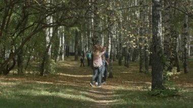 Mutlu genç aile güneşli bir gün açık havada sonbahar parkında eğlenceli yaşıyor. Anne, babam ve küçük çocuk parkta yürüyorlar. Aşk ve aile konsepti.