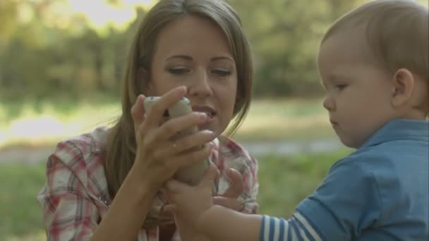 Mutter hilft kleinem Sohn, Vater mit Telefon anzurufen. — Stockvideo