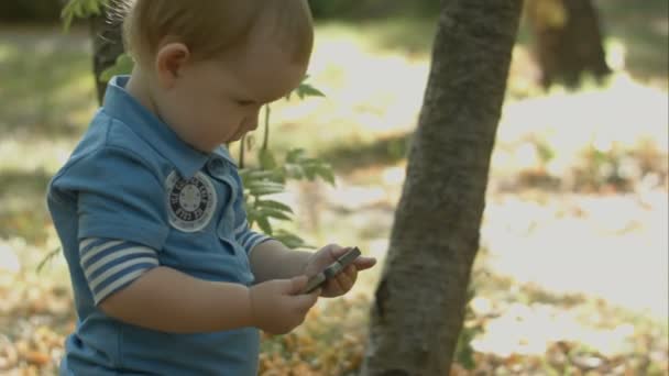 Adorable bébé regarder bande dessinée sur smartphone dans le parc .