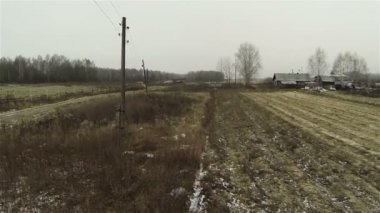 Sürülmüş alanların havadan görünümü, sonbahar çiftliği, kış başlar, ilk kar, sütunlar grilik ile kırsal yol