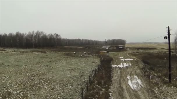 Вид з повітря на брудну дорогу на ферму в сільській місцевості, Росія перший сніг, осінь, погана погода — стокове відео