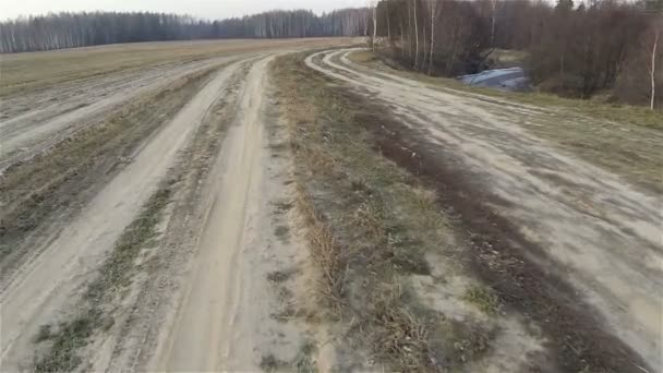 Flygbild av BIVÄG trodde fältet i landsidan, sand Dirty Road, nära Icy Forest River, höst vinter Ryssland — Stockvideo