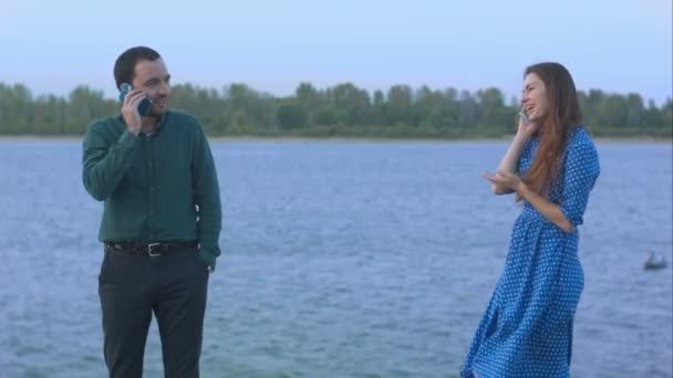 Hombre y mujer con teléfonos celulares hablando . — Vídeos de Stock