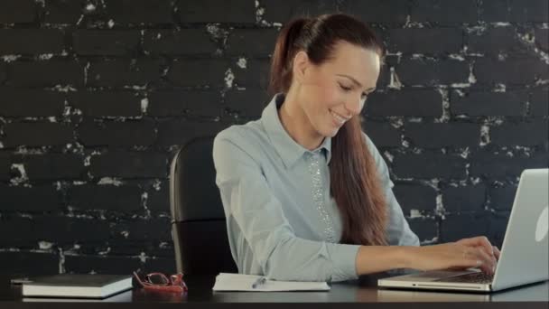 Empresária feliz que trabalha no computador portátil no escritório — Vídeo de Stock