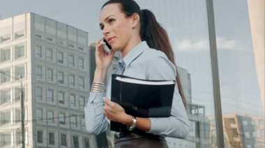 Mutlu gülümseyen iş kadını cep telefonu üzerinden konuşma ve belgeleri tutarak.