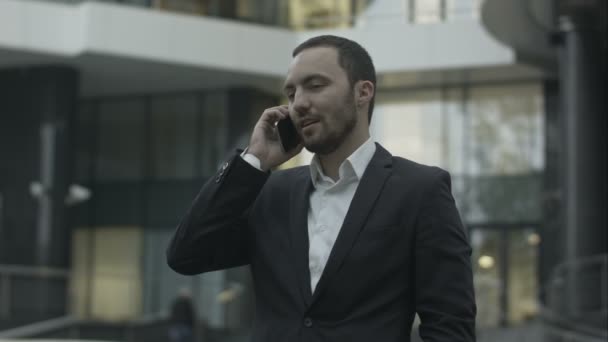 Ευτυχισμένος επιχειρηματίας απαντώντας κλήση και να μιλήσει με παρτενέρ που στέκεται έξω από το γραφείο — Αρχείο Βίντεο