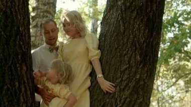 Onun küçük kızı ile mutlu bir çift bir orman arka plan üzerinde öpüşme